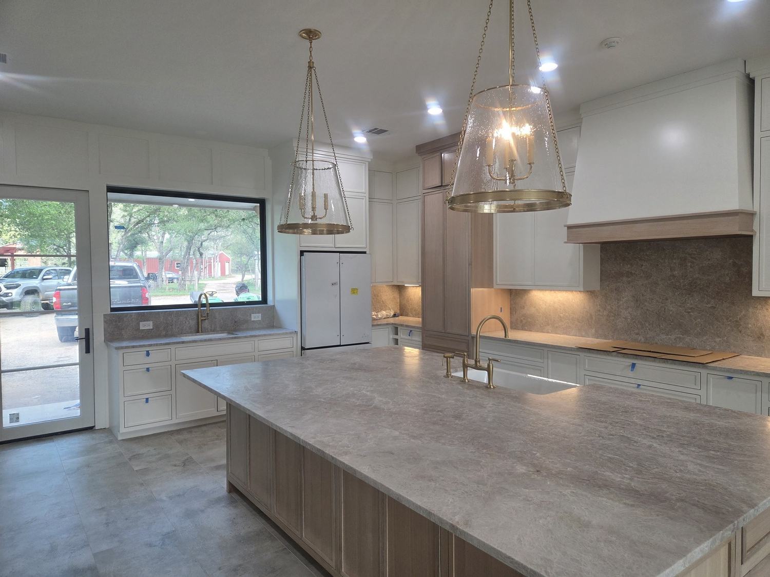 Completed custom kitchen with large island and pendant lighting